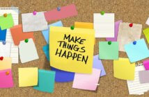 Cork board full of thumbtacked notes including a big one that says MAKE THINGS HAPPEN!