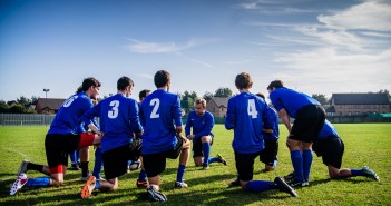 To the Point: Stop Complaining about Sunday Morning Sports Stock photo of a group of young male soccer players in a huddle