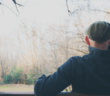Person sitting on a bench looking at nature