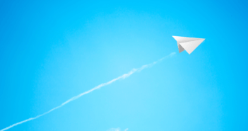 Paper airplane soaring into the sky